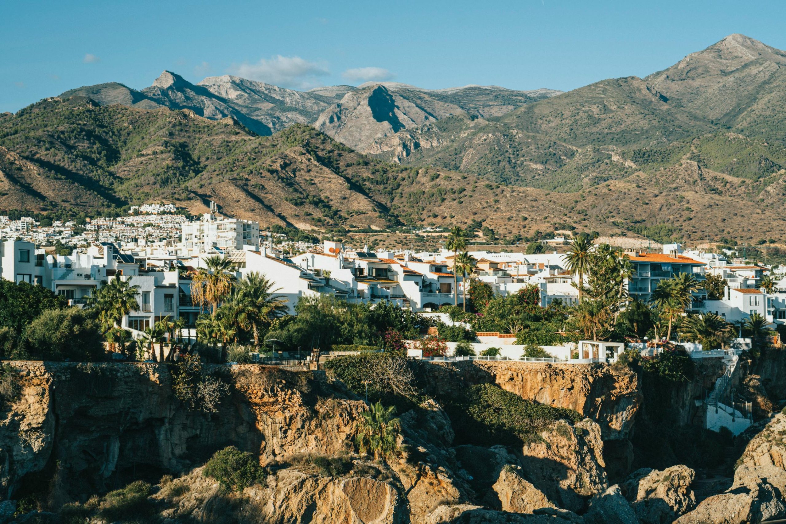 Nerja desde vista aérea desde el mar, con las montañas de fondo y el pueblo de casas blancas